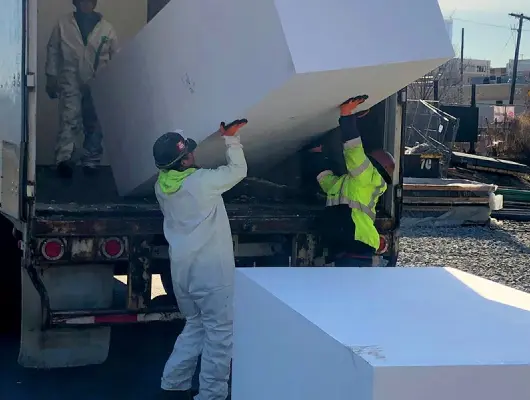 Two men unload large geofoam blocks